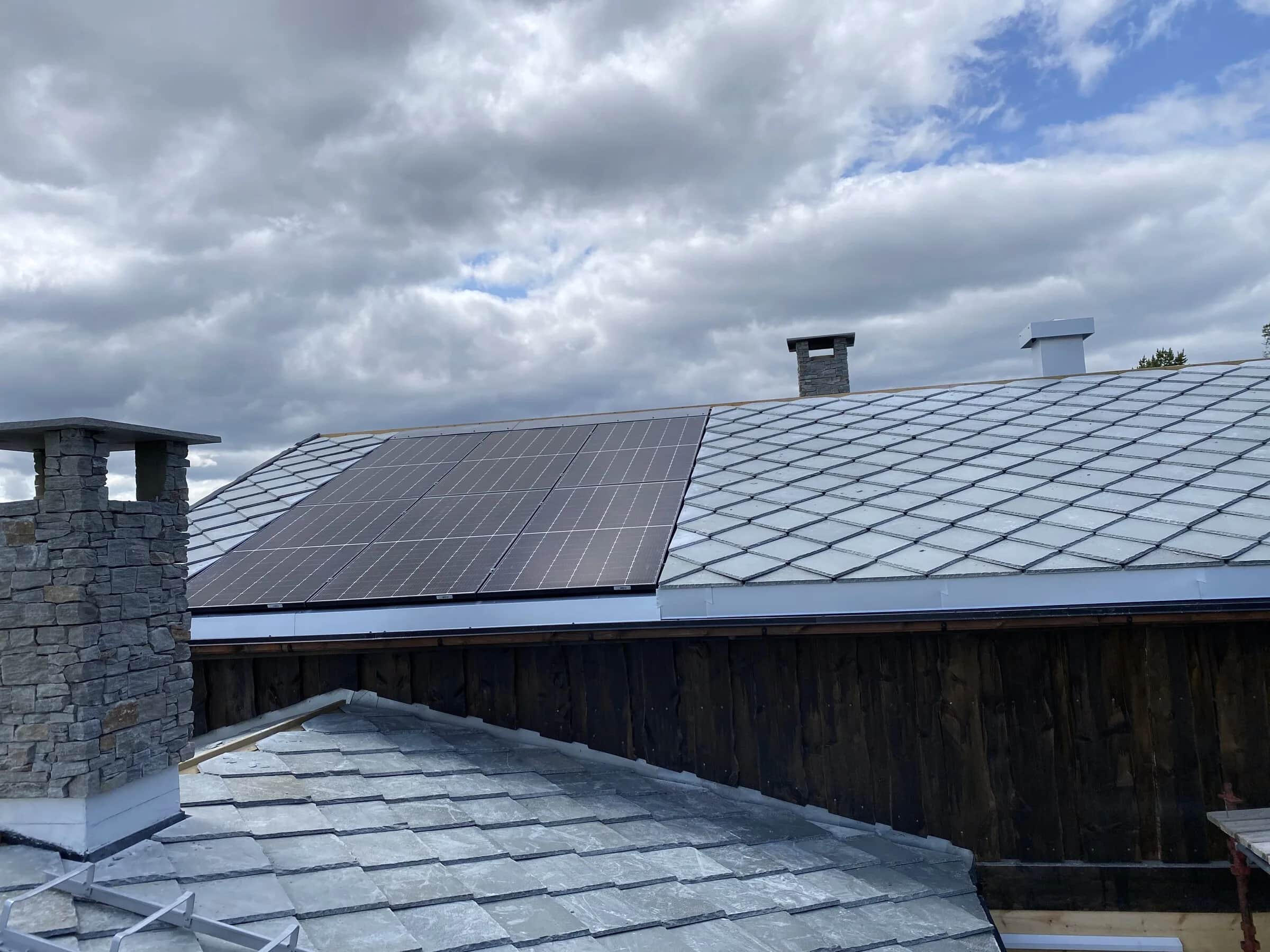 Nylagt skifertak på hytte mot blå himmel